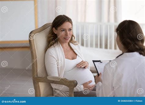 Gynecologist Asking Female Patient To Sit On Gynecological Chair For Examination Stock Image