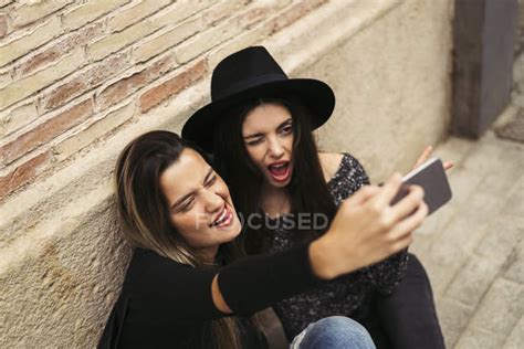 Two Best Friends Pulling Funny Faces While Taking Selfie With Cell