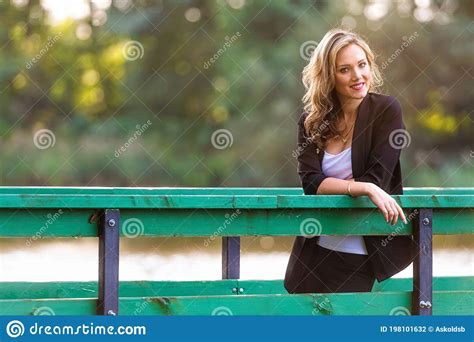 Portrait Of Young Attractive Woman Leaning On A Railing Of Pedestrian