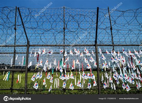 Fence With Barbed Wire And South Korean Flags At The Demilitarised Zone