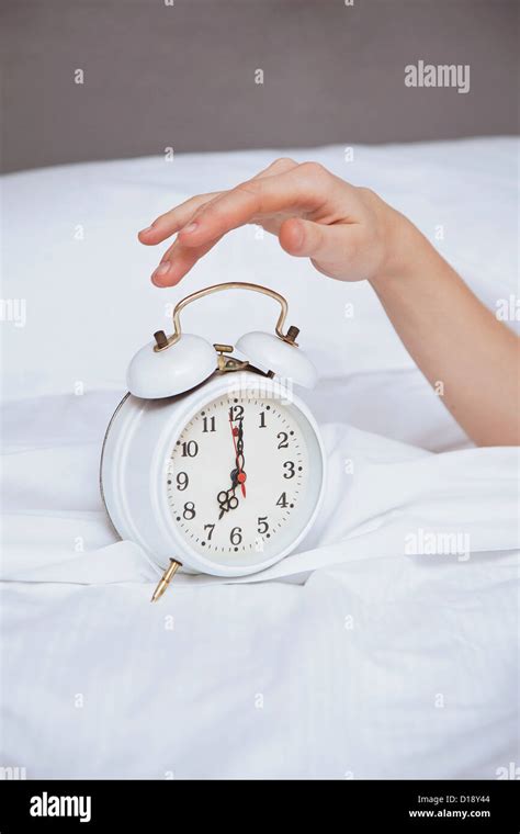 Female Hand Reaching For Alarm Clock Stock Photo Alamy