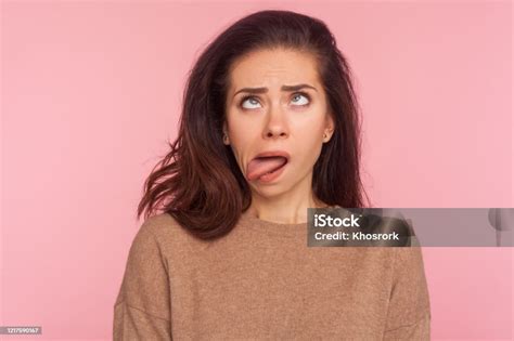 Portrait Of Funny Silly Young Woman With Brunette Hair Looking Cross Eyed And Sticking Tongue