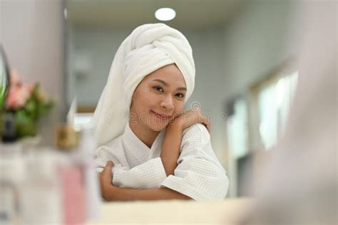 Pleased Beautiful Woman With Towel On Head Hugging Herself And Looking In Mirror Self Care And