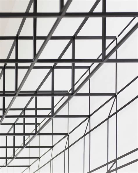 The Ceiling Is Made Up Of Black Metal Bars And Grids That Are Connected