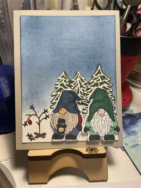 Two Gnomes Standing Next To Each Other On A Table