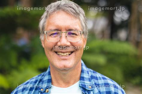 Portrait Of Smiling Caucasian Senior Man Standing In Backyard On Weekend Unaltered Lifestyle