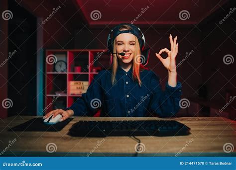 Smiling Female Gamer In Casual Clothes And Headset On Her Head Sitting