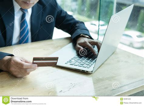 Male Holding A Credit Card And Using Laptop Computer For Online Stock