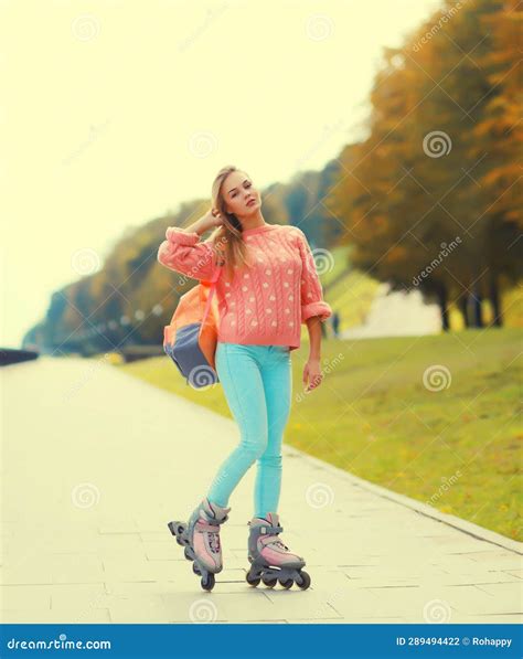 Stylish Blonde Young Woman On Roller Skates With Backpack Posing In