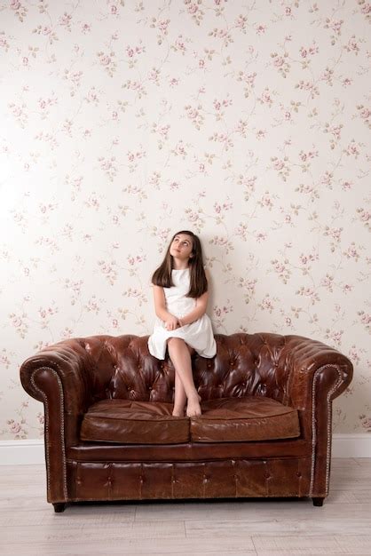 jeune fille assise sur un canapé en cuir photo premium