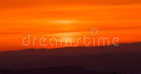 Sunset Scene With Sun Fall Behind The Clouds And Mountains In