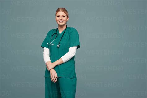 Happy Female Doctor Smiling At The Camera While Standing Against A