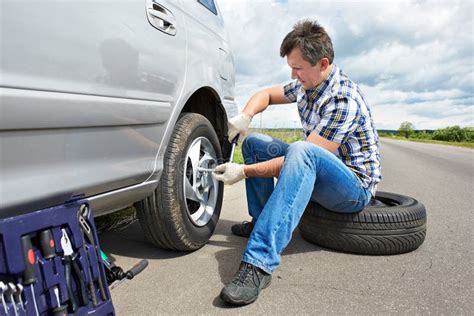 Man Changing Spare Tire Of Car Stock Photo Image Of Casual Help