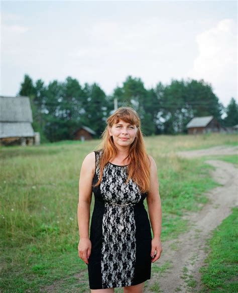 A Woman Standing In The Middle Of A Dirt Road