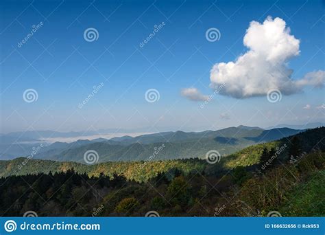 Solitary White Cloud Hovering High Above The Mountains Stock Photo