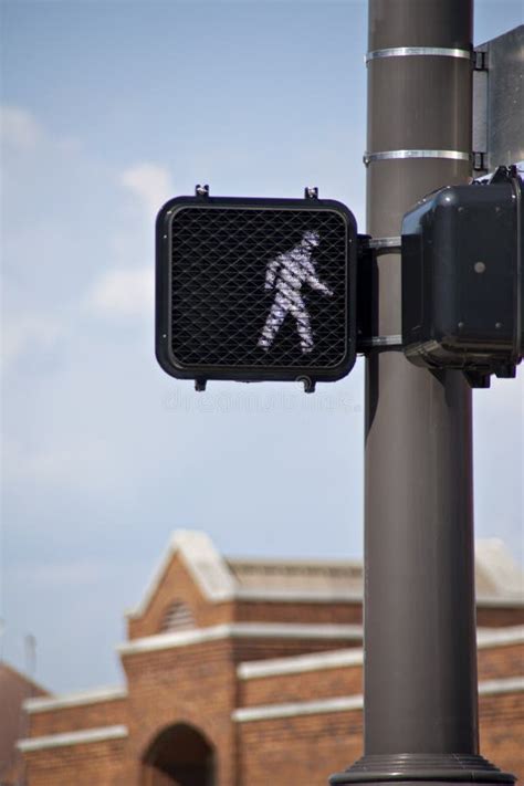 Electronic Crosswalk Sign Surrounded By Blue Sky And Brick Build Stock