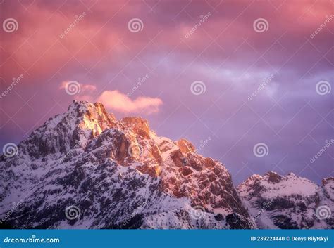 Beautiful Mountain Peaks In Snow And Violet Sky With Pink Clouds Stock