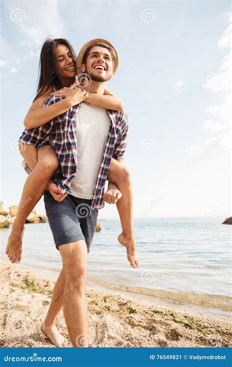 Man Giving Piggy Back Ride To His Girlfriend At Beach Stock Image