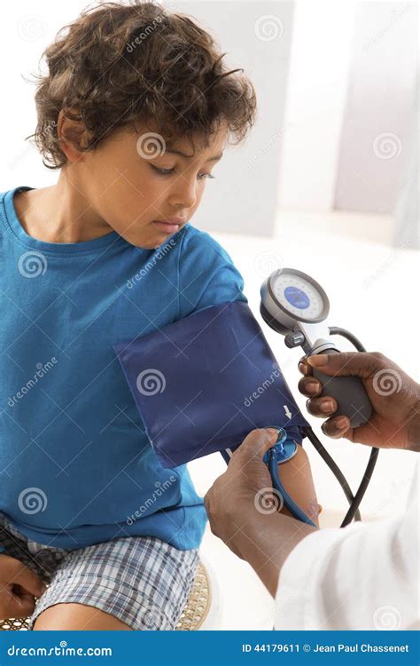 African American Woman Doctor Taking A Childs Blood Pressure Stock