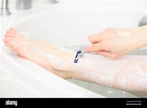 Caucasian Woman Shaving Her Leg In Her Bathtub Detail Of Leg Being
