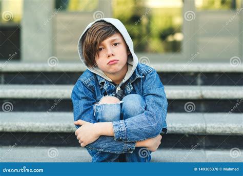Sad Boy Is Sitting On The Stairs Before School Alone Unhappy Child In