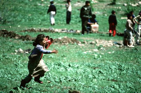 A Kurdish Child Runs To Her Parents After Receiving A Pair Of Sandals