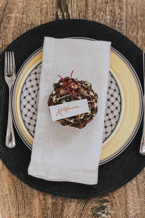 Place the stems of fresh flowers and greenery sprigs in the hole of paper tags for these sweet diy place cards. DIY Thanksgiving Place Card Holders | Style Waltz