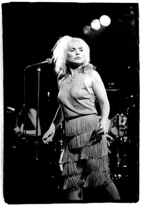 A Black And White Photo Of A Woman On Stage With A Microphone In Her Hand