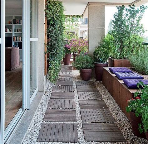 An Outdoor Patio With Potted Plants On The Side And Wooden Benches In
