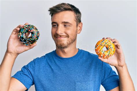 Handsome Caucasian Man Holding Tasty Colorful Doughnuts Smiling Looking