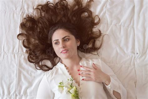 Pretty Young Woman With Beautiful Long Hair Lying On The Bed Stock
