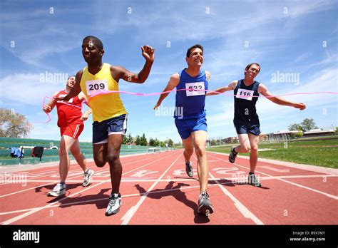 Track Runners Cross Finish Line Stock Photo Alamy