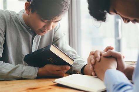 Dois Cristãos Estão Orando Juntos Pela Bíblia Sagrada Foto Premium