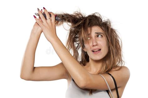 A Mad Woman With The Messy Hair Holding Comb And Hair Brush Stock Photo