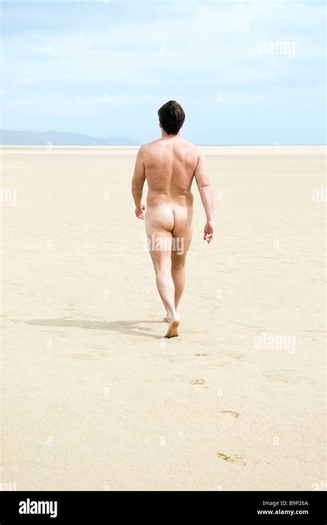 A Naked Man Walks Alone On A Large Sandy Beach In Sotovento