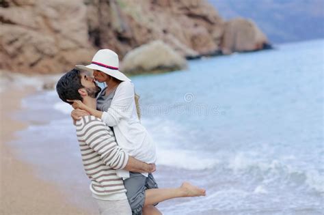 Pares De Las Vacaciones Que Recorren En La Playa Junto En El Amor Que Se Sostiene Alrededor De