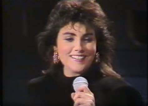 A Woman Holding A Microphone In Her Right Hand