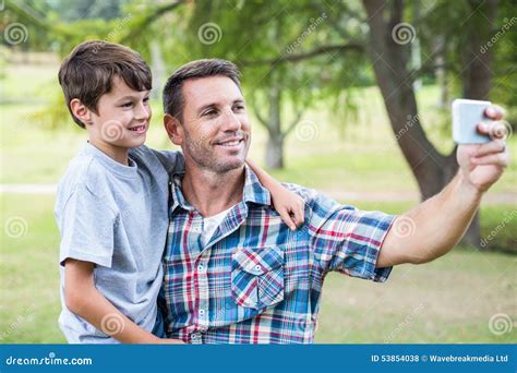 Padre E Hijo Que Toman Un Selfie En El Parque Foto De Archivo Imagen