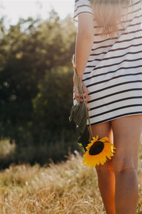 Woman Holding Sunflower While Walking Photo Free Flower Image On Unsplash