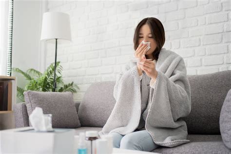 Sick Young Asian Woman Sit Under Blanket On Sofa Female Blow Nose