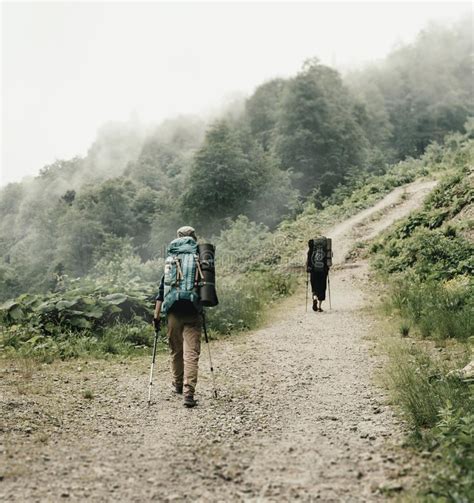 Two Hikers Walking On The Path In Mountains Stock Photo Image Of