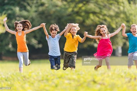 Happy Children Running In The Park And Having Fun High Res Stock Photo