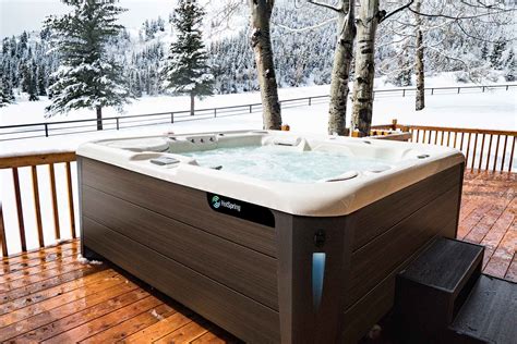 hotspring highlife envoy 2019 alpine white walnut lifestyle snow 01 web great atlantic hot tubs