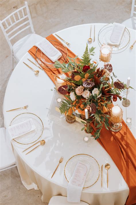 Main Wedding Table With Burnt Orange Table Runner Decorated With A Floral Centerpiece Alongside