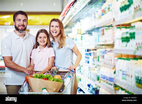 Cheerful family with shopping cart visiting supermarket Stock Photo - Alamy