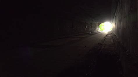 Man Walking Down Dark Tunnel Towards Light Stock Video