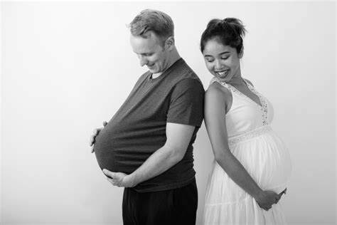 premium photo man with watermelon as stomach and pregnant asian woman together as multi ethnic