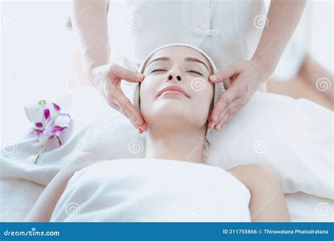 Female Massage Therapist Giving A Massage At A Spa Young Woman Receiving Head And Facial
