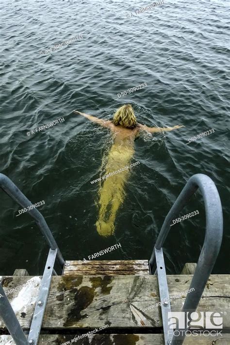 Stockholm Sweden A Woman Bathes Naked In Lake Malaren From A Dock