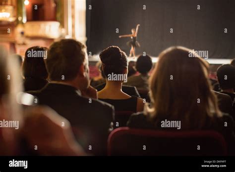 Rear View Of Theater Audience Watching Performers On Stage Stock Photo